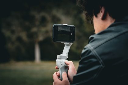 Pessoa utiliza um estabilizador de smartphone ao ar livre para gravar um vídeo com mais estabilidade.