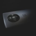 Detalhe aproximado do módulo de câmeras traseiras de um smartphone moderno sobre fundo escuro.