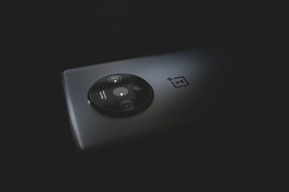 Detalhe aproximado do módulo de câmeras traseiras de um smartphone moderno sobre fundo escuro.