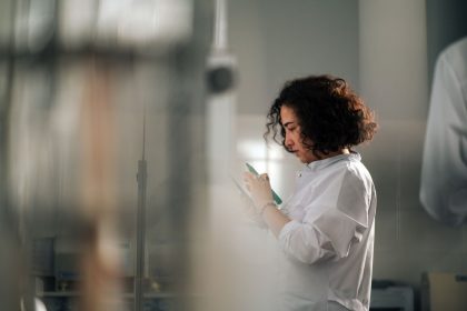 Pesquisadora faz anotações em um laboratório durante atividades relacionadas ao desenvolvimento de medicamentos