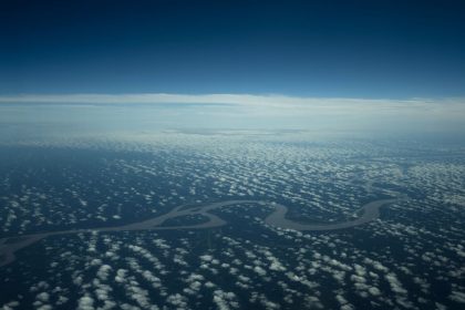 Vista aérea de um rio amazônico serpenteando por uma área de floresta densa.