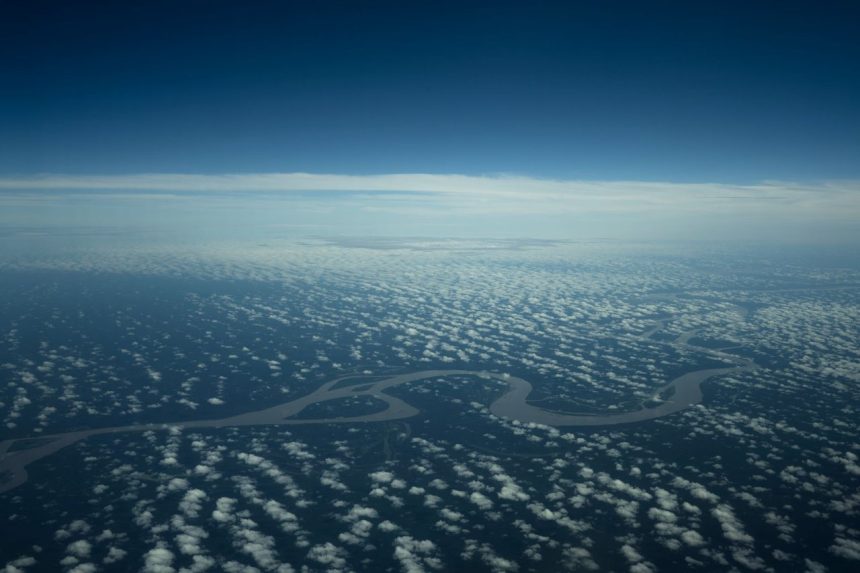 Vista aérea de um rio amazônico serpenteando por uma área de floresta densa.