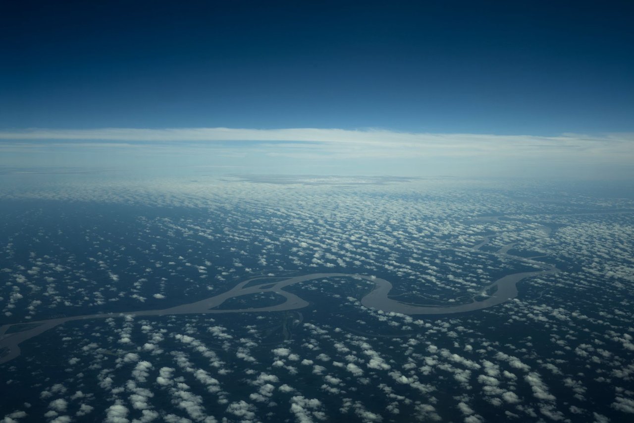 Vista aérea de um rio amazônico serpenteando por uma área de floresta densa.