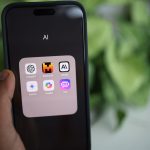 Smartphone exibindo aplicativos de inteligência artificial sobre um laptop, em uma composição com plantas ao redor