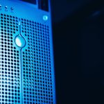 Rack de servidores em uma sala de datacenter moderna, iluminada em tons de azul.