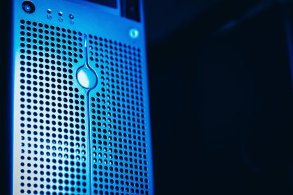 Rack de servidores em uma sala de datacenter moderna, iluminada em tons de azul.