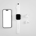 Smartphone, smartwatch e fones de ouvido sem fio dispostos sobre fundo branco.