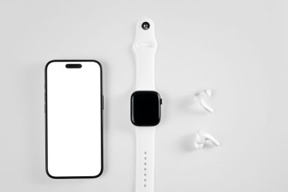Smartphone, smartwatch e fones de ouvido sem fio dispostos sobre fundo branco.